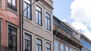 Una hilera de edificios de varios pisos con un estilo arquitectónico uniforme, con balcones y grandes ventanales.