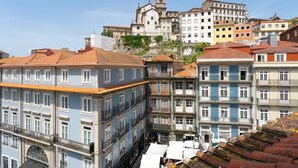 Edifici històric amb una torre de l'ajuntament, envoltat d'edificis de colors amb balcons i terrasses de teules.