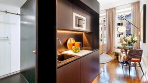 Een moderne keuken met een ingebouwde magnetron, een spoelbak en een aanrecht met een fruitschaal en een vaas.