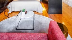 Une chambre moderne avec un grand lit, des tables de chevet et un plafond à la structure originale.