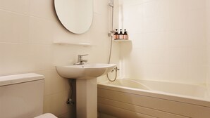 Un baño con inodoro, lavabo, espejo y bañera.