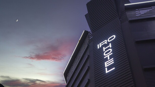 Un hotel con un diseño arquitectónico moderno, destacando un cartel prominente que dice 'HOTEL' en la fachada.