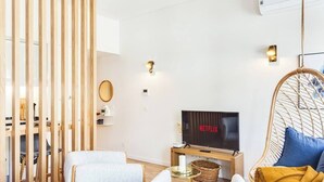 A modern living room with a television, seating, and a decorative wall panel. - Boavista Blue Studio by DA'HOME (Porto)
