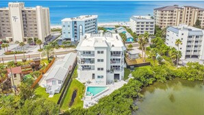 Ein Hotelkomplex an der Küste mit mehreren Gebäuden, einem Schwimmbad und Blick aufs Meer.