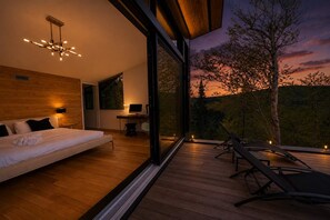 Une chambre moderne avec un grand lit, un bureau et une vue sur l’extérieur.