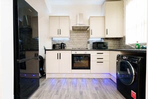 Uma cozinha moderna com forno embutido, micro-ondas e máquina de lavar louça.