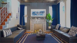 A living room with a fireplace, two sofas, a coffee table, and a staircase. - Nine20 Collins (Miami Beach)