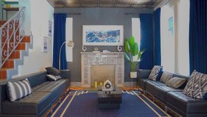 Ein Wohnzimmer mit Kamin, zwei Sofas, einem Couchtisch und einer Treppe.