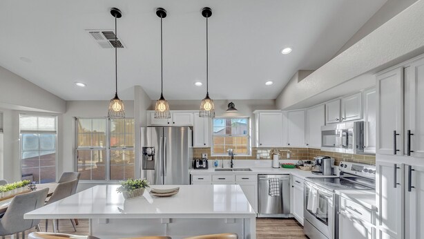 A modern kitchen with white cabinets, stainless steel appliances, and pendant lighting. - Recently renovated Phoenix home with private heated pool and mountian veiws  (Phoenix)