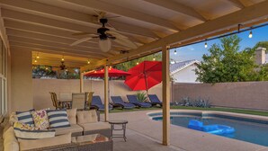 A covered outdoor area with a pool, lounge chairs, and umbrellas. - Recently renovated Phoenix home with private heated pool and mountian veiws  (Phoenix)