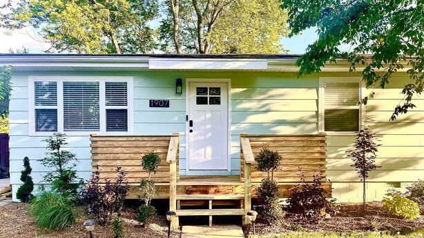 Einbungalow mit Veranda, Briefkasten und kleinem Garten.