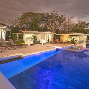 A modern pool area with lounge chairs and a clear blue pool. - Adeluna Luxury Ocean View Villas (Cóbano)