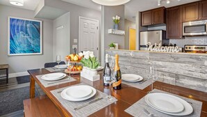 Une cuisine moderne avec des meubles en bois, un four à micro-ondes encastré et un panneau d’accueil.