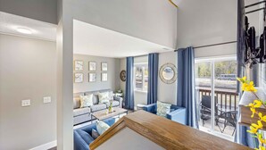 Un salon moderne comprenant un ensemble de canapés, une table basse et un coin repas avec des chaises.
