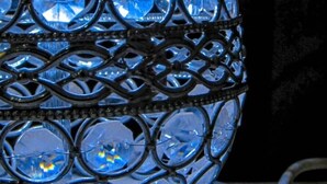 A spherical chandelier with multiple clear glass elements and a metal frame.