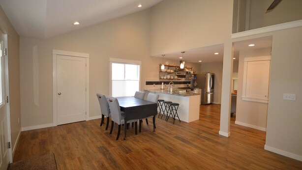 A spacious kitchen with a central island, wooden flooring, and recessed lighting. - Boyne Bungalow (Boyne City)