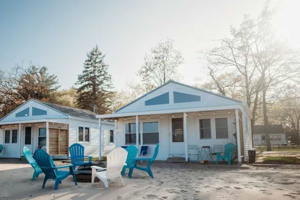 A beachfront cabin with outdoor seating and a covered porch.
