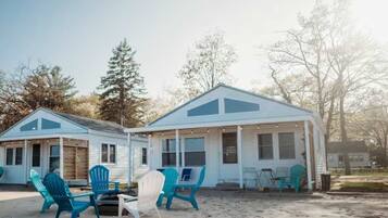 A beachfront cabin with outdoor seating and a covered porch.