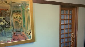 A hallway with a wooden railing, a door with glass panels, and a framed painting on the wall. - Walk to Beach, shops, restaurants and much more! (Long Beach)