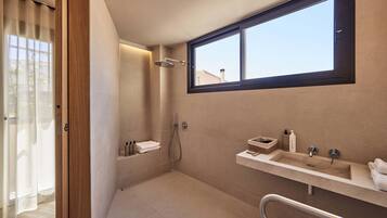 Un baño moderno con ducha, lavamanos y ventana.