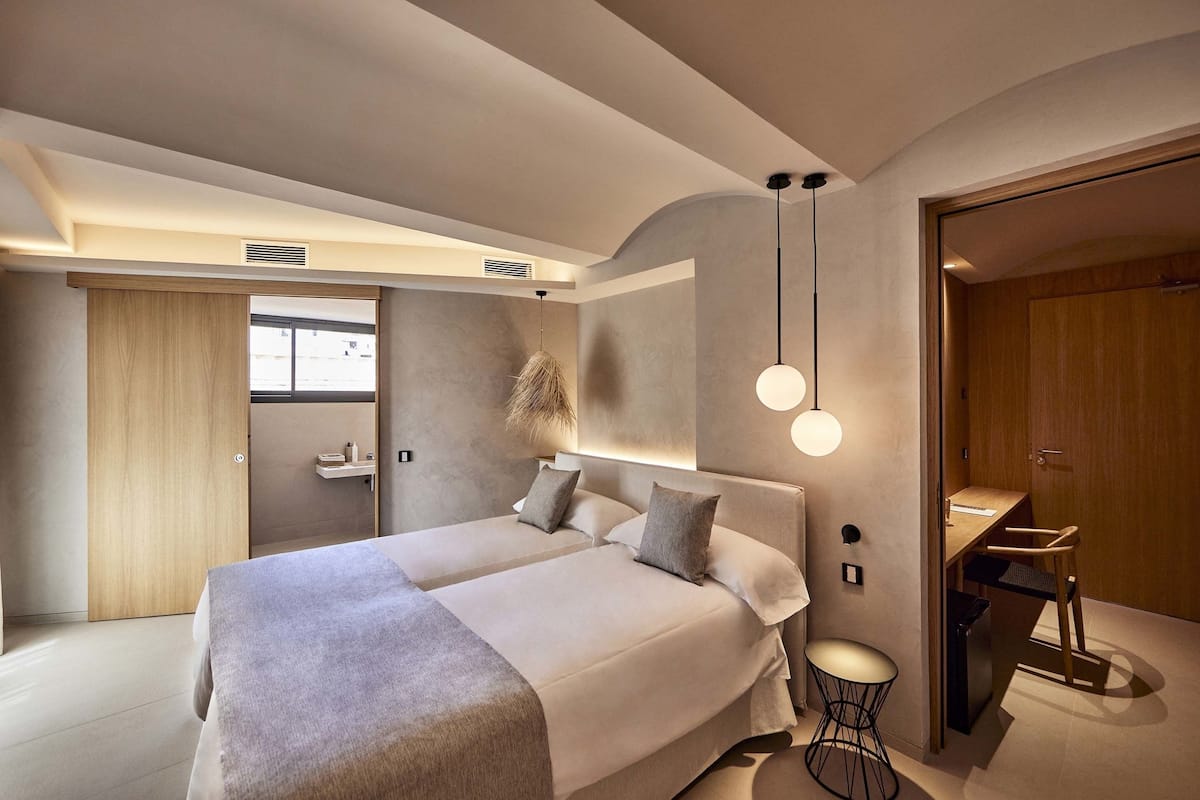 Une chambre moderne avec un grand lit, des tables de chevet, un bureau et une chaise.