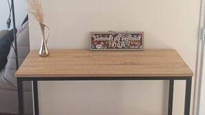 Ein Zimmer mit einem Holzschreibtisch, einem goldfarbenen Spiegel und einem Schild mit Text.