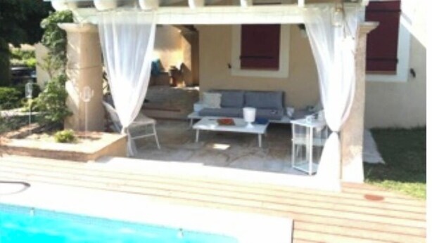 A covered outdoor seating area with a pool, a patio, and a view of the interior. - Maison Dans Domaine Avec Piscine (Le Tholonet)