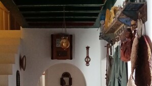A narrow hallway with patterned floor tiles, a staircase with red and green railings, and a small table with a hose. - Dar Soulayma vacation home (Fatou houmet souk Djerba)