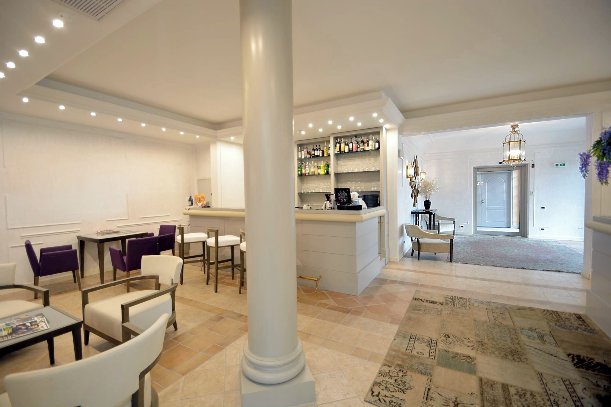 A hotel lobby with a bar area, seating arrangements, and a patterned carpet.