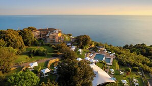 Un gran complejo turístico con piscina, varias zonas de descanso y vistas al mar.