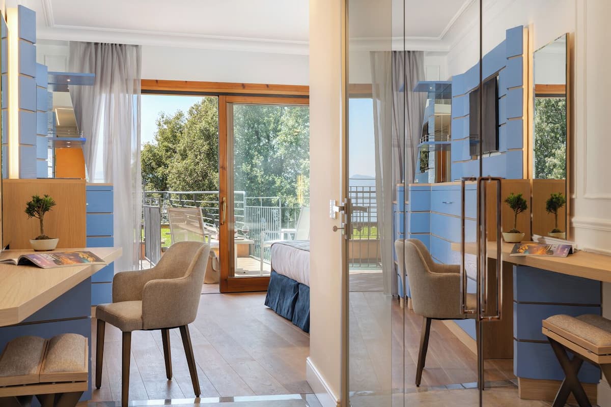 Une chambre d’hôtel moderne avec un balcon, un bureau et un lit.