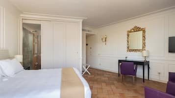 Une chambre d’hôtel équipée d’un lit, d’un bureau, d’une chaise, d’un miroir et d’un espace douche.