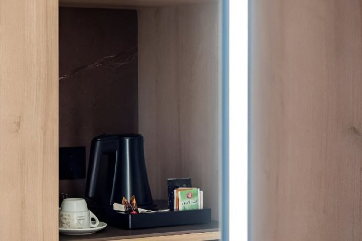 A small kitchenette with a coffee maker, a cup, and a box of tissues.