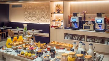 A breakfast buffet with various food items, a coffee station, and seating areas.