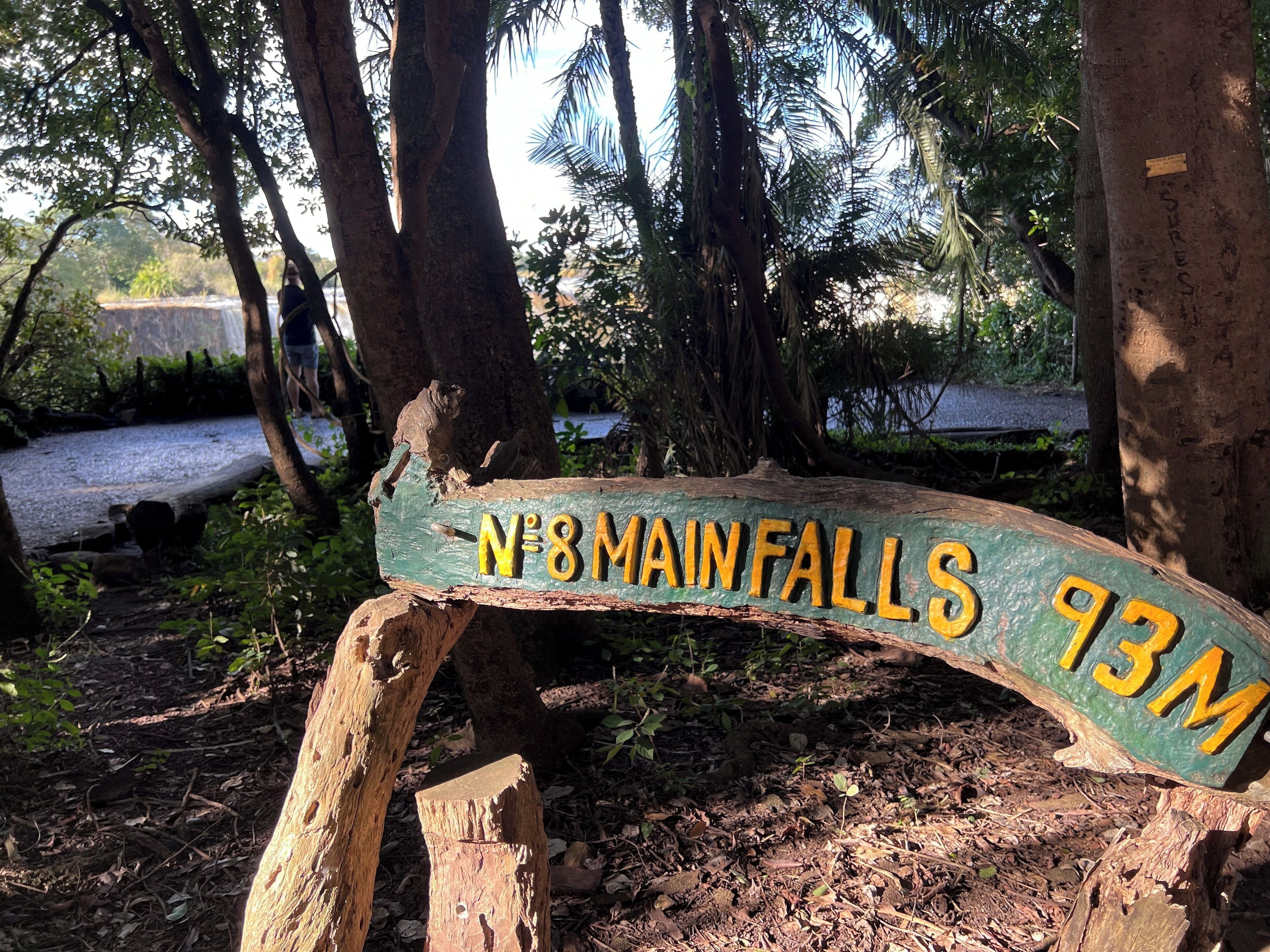 A wooden sign with the text "N°8 MAIN FALLS 93M" indicating the location of the main falls at 93 meters.