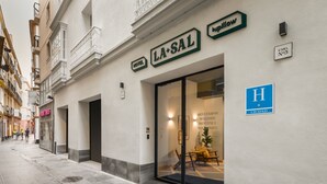 Un hotel llamado LA+SAL con una entrada moderna y una recepción visible.
