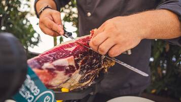 Una persona cortando carne sobre una tabla.