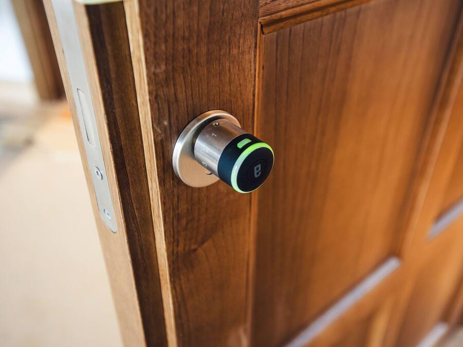 Een houten deur met een modern elektronisch slot.
