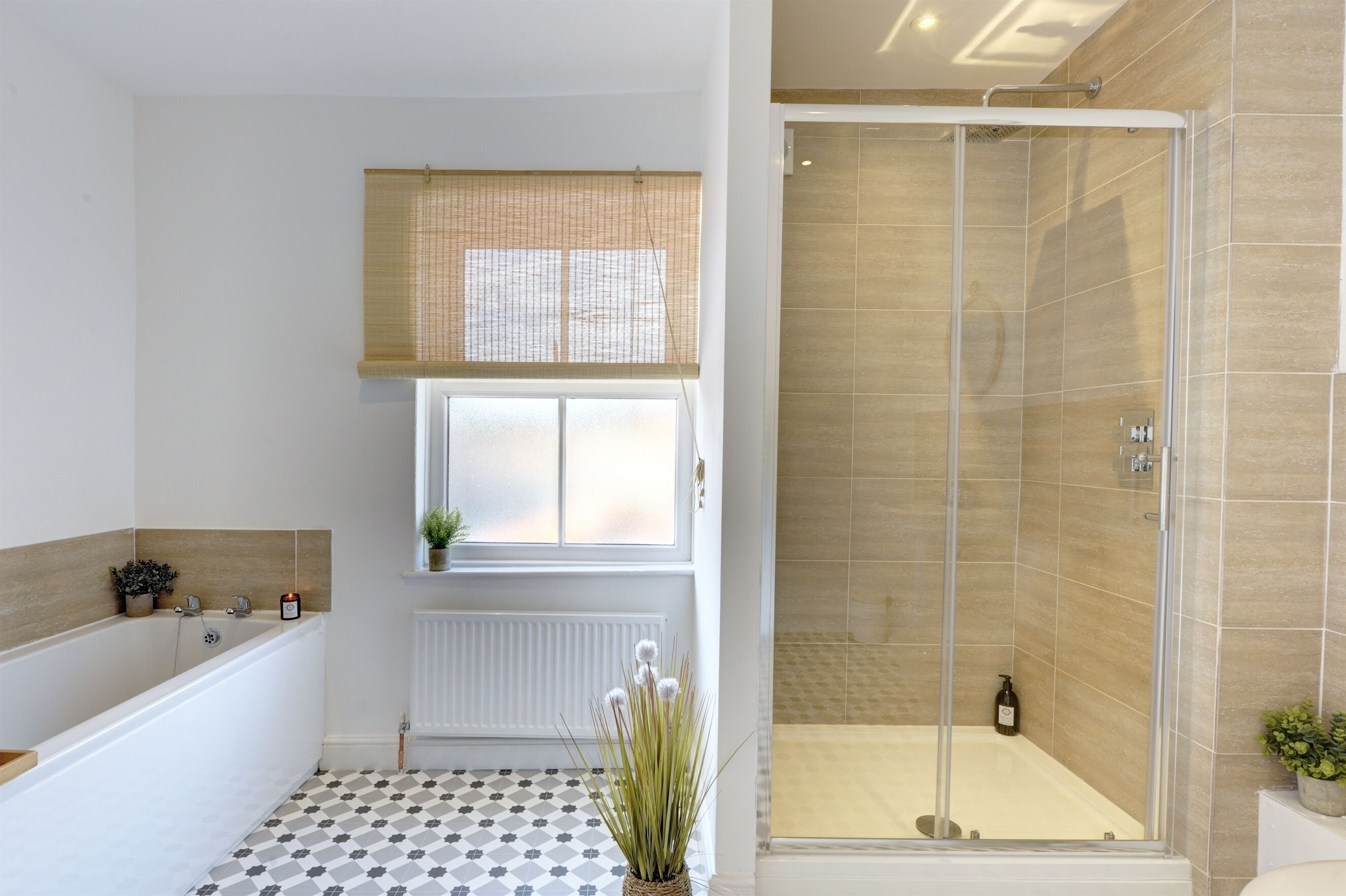 Een badkamer met een bad, een douche en een raam met uitzicht.