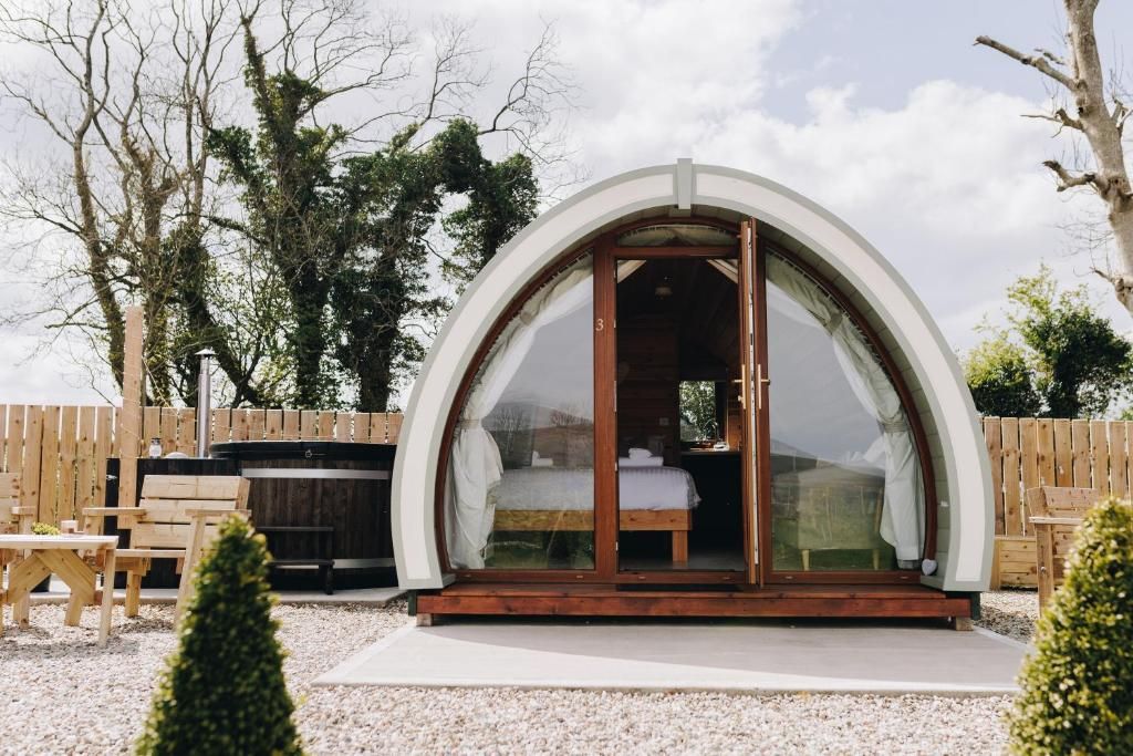 Una habitación con techo abovedado, una cama, un jacuzzi y una terraza de madera.