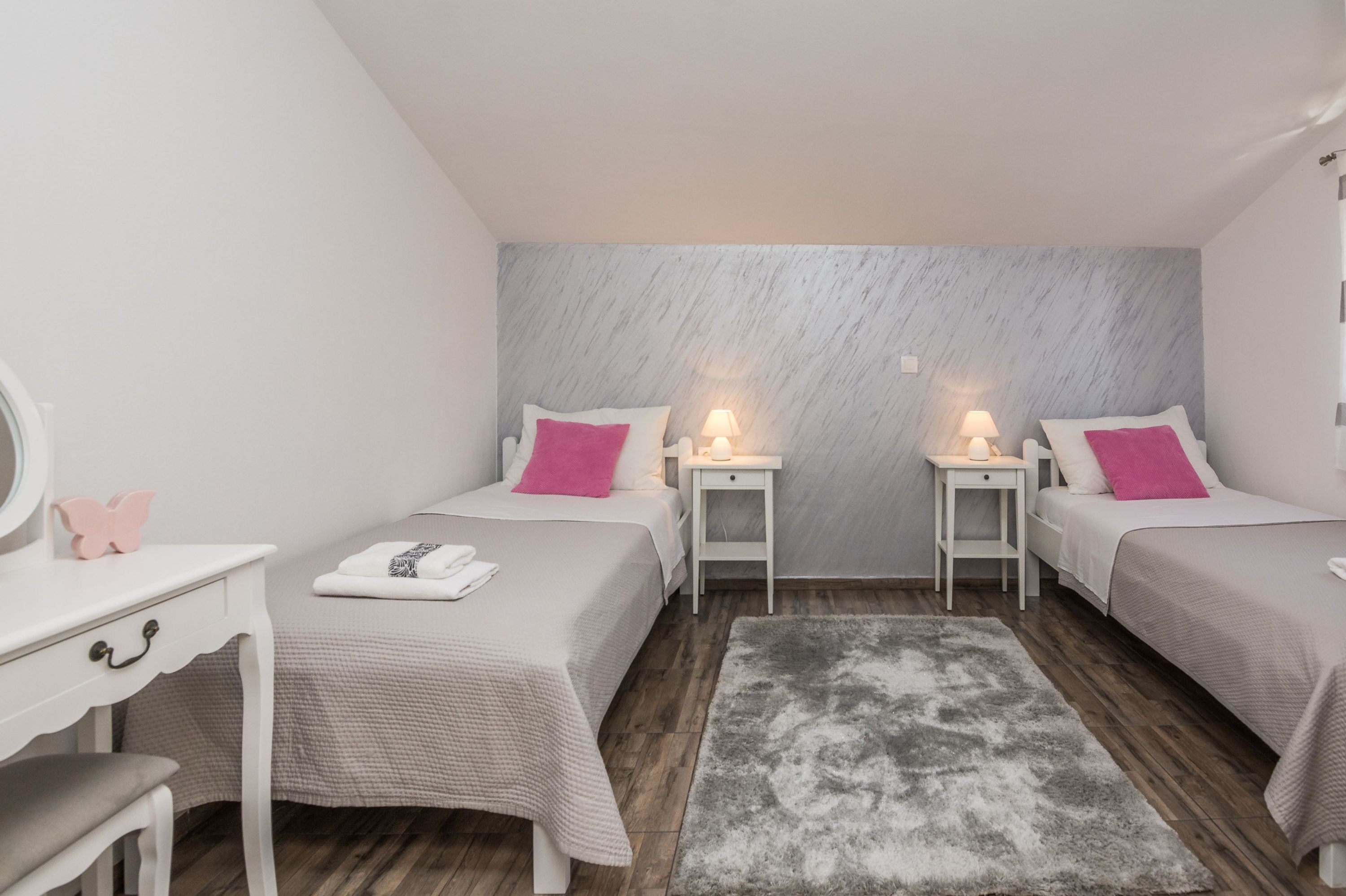 Ein Schlafzimmer mit zwei Betten, einem Schreibtisch und einem Spiegel.