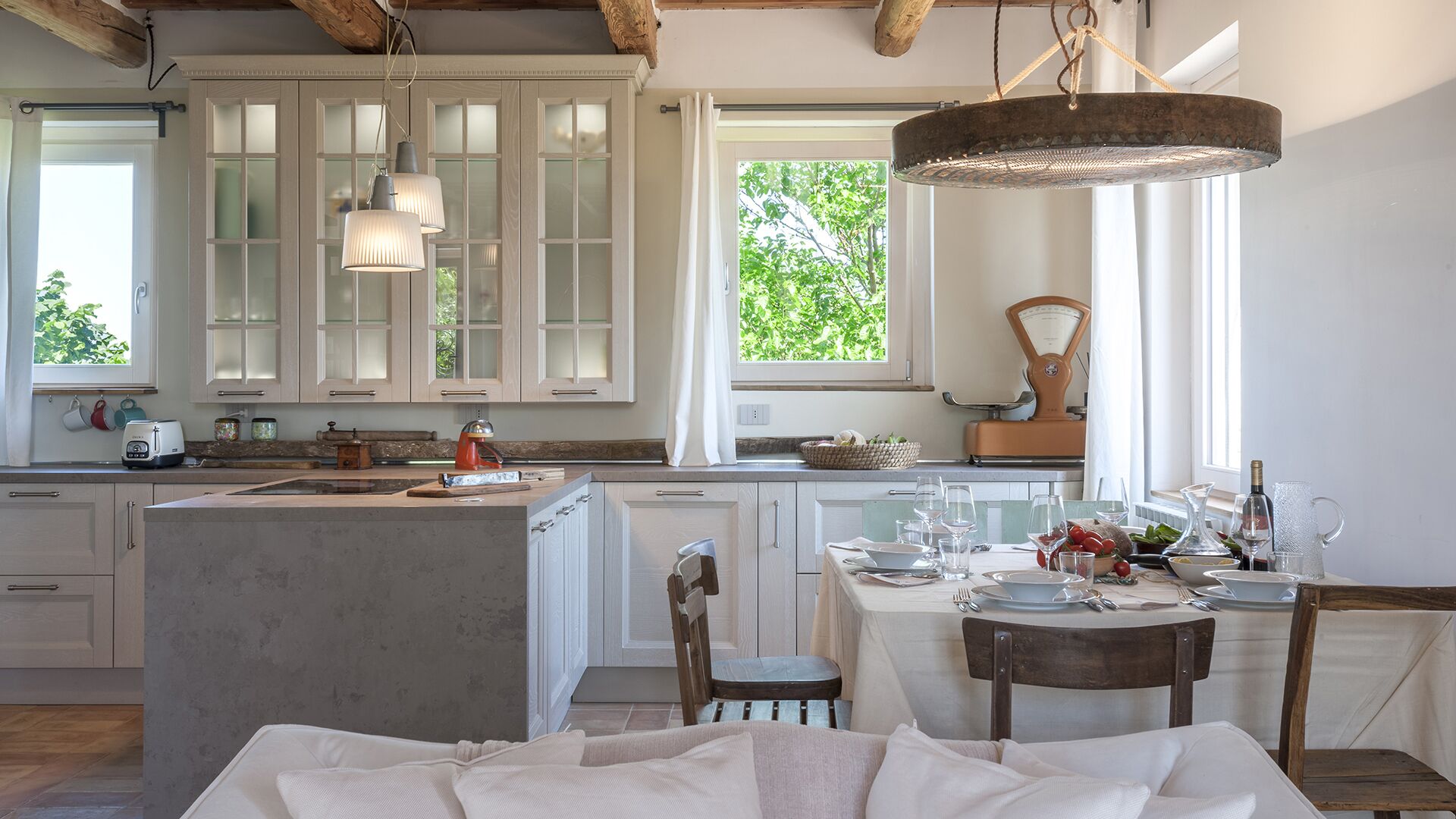 Una cocina con una isla central, armarios de madera y una lámpara colgante.