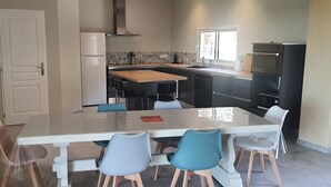 A modern kitchen with a central island, a built-in oven, and a dishwasher.