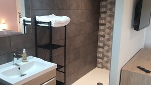 A bathroom with a white sink, a mirror, a towel rack, and a toilet.