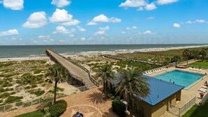 A beachside resort with a pool, beach access, and a boardwalk.
