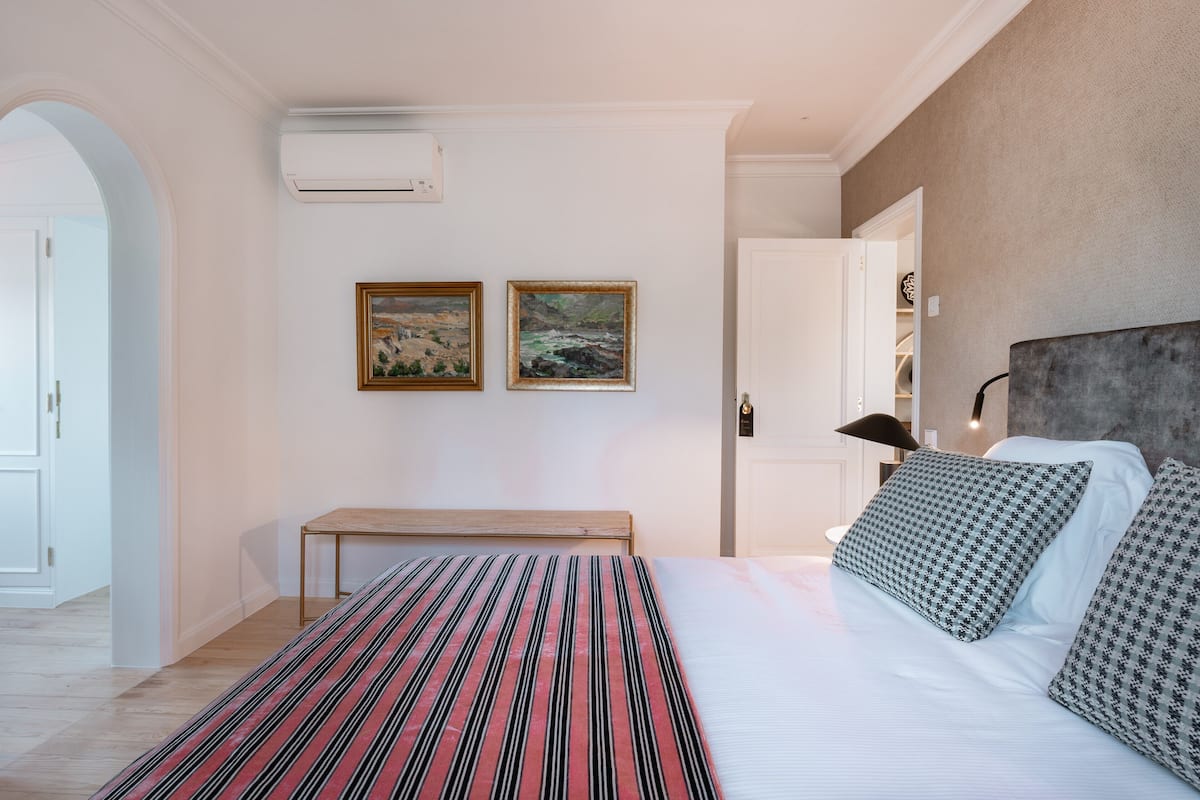 Ein Schlafzimmer mit einem Bett, zwei Bildern, einem Nachttisch und einem Kopfteil.