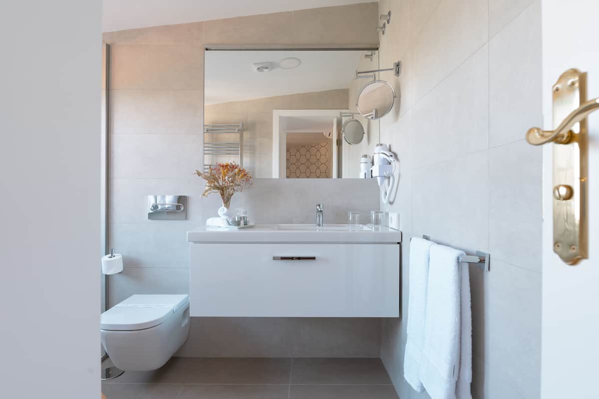 Ein modernes Badezimmer mit Toilette, Waschbecken und Handtuchhalter.