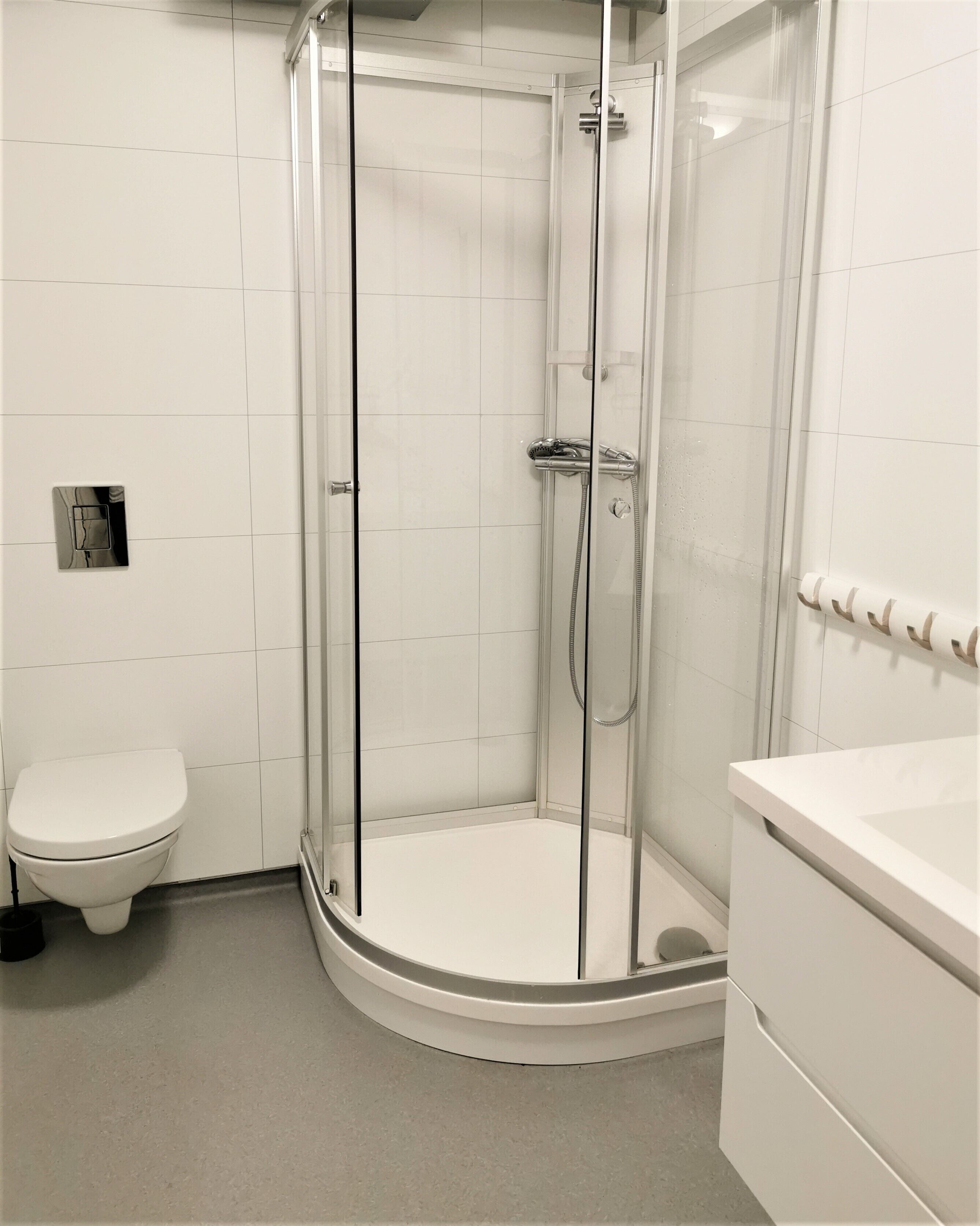 Un baño moderno con ducha acristalada, inodoro y lavabo.