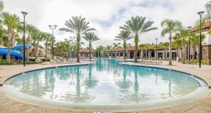 A swimming pool with a water slide, surrounded by palm trees and lounge chairs. - Waterpark, Lazy river! Disney pool home. (Davenport)