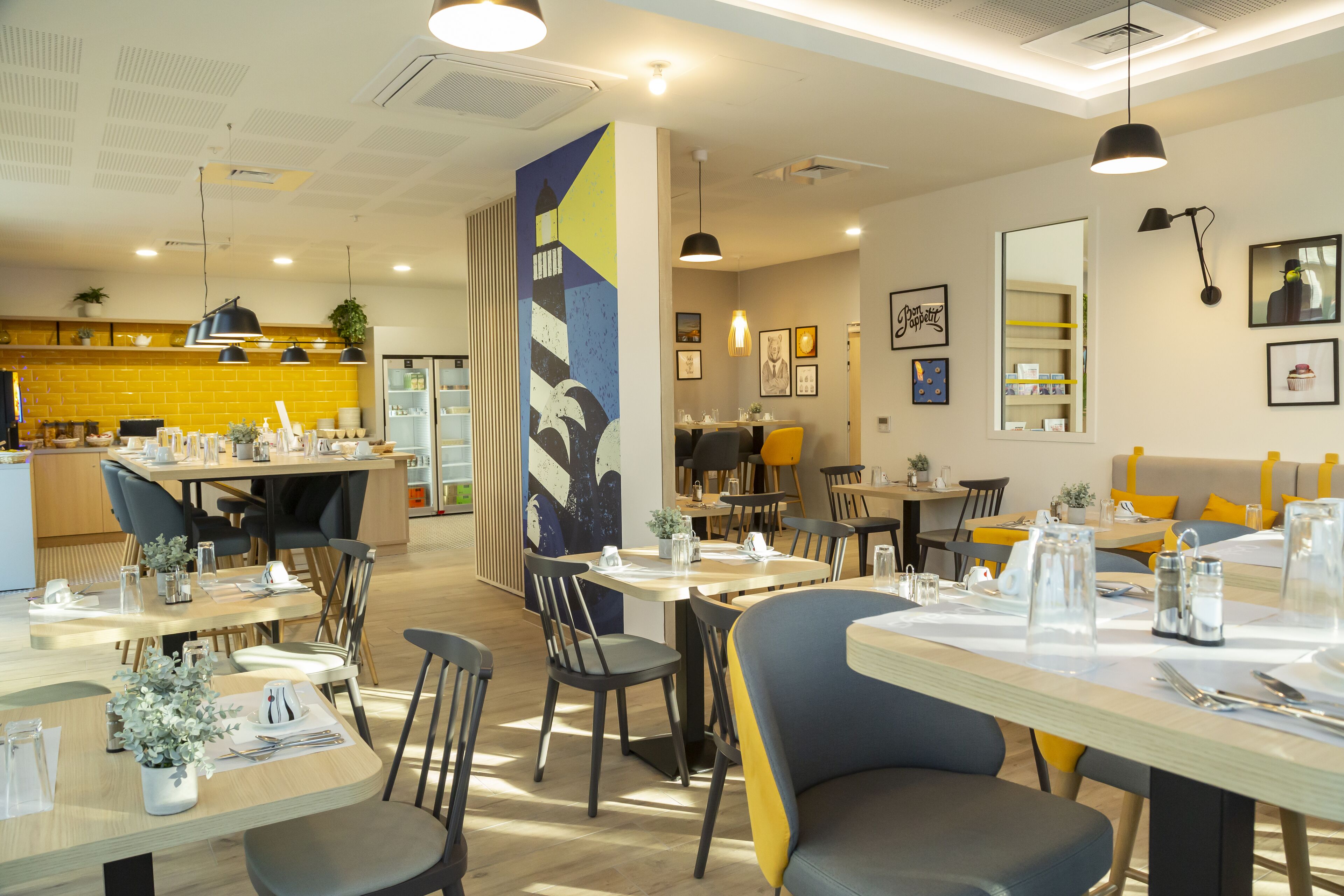 A modern restaurant with multiple dining areas, including a bar and a seating area with tables and chairs.
